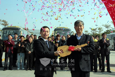 大金龙国内销售部经理杨国军向贵州紫运集团董事长沈继陵（右）交“金钥匙”