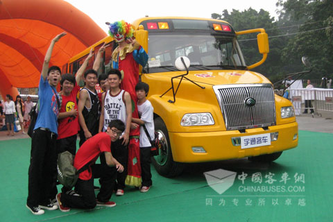 参观文艺表演的演员与校车合影