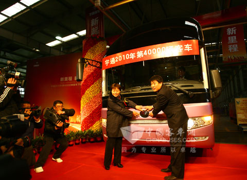 郑州交运集团董事长（左一）与雷勇贴上经典的宇通车标