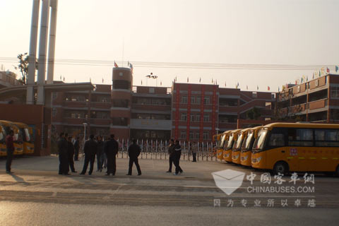 洪湖市峰口镇明德小学门口整齐排列的东风莲花校车