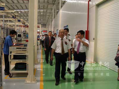 丁国炎在（前左一）在李天生陪同下参观厦门玉柴公司生产车间