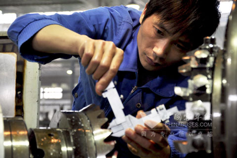 一员工正在认真检测军品桥齿轮